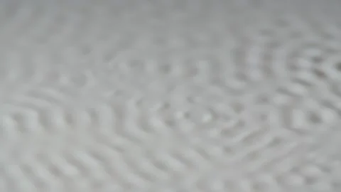 Cymatic patterns form on the white surface of the milk. The art of creating Stock Footage 155286815