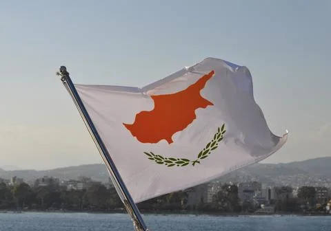Cyprus flag on the flagpole in the open blue sea Stock Photos