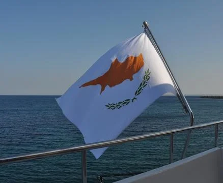 Cyprus flag on the flagpole in the open blue sea Stock Photos