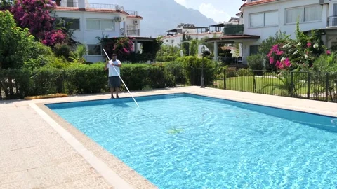 Cyprus, Larnaca, September 10, 2019. Two workers clean a private pool Stock Footage 130511447