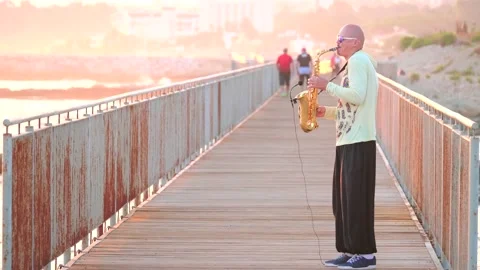 Cyprus, Larnaca, September 16, 2019. Young bald man street musician saxophonist Stock Footage 148031587