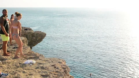 CYPRUS, SENTEMBER 2018: Man jumping from the rock rocks of Cape Greco in to a se 動画素材 96337819