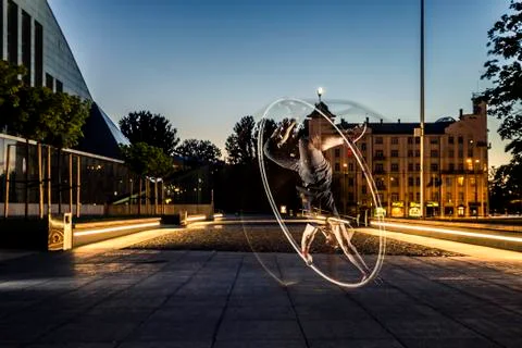 Cyr wheel performance session by young man at night. Stock Photos