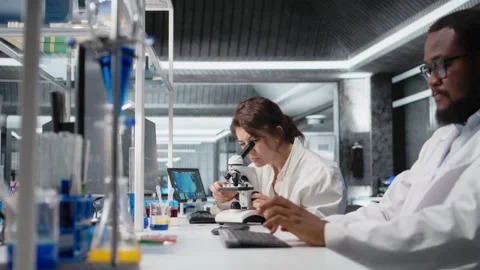 Cytotechnologist adjusts microscope, zooms on cellular structures in lab Video stock 320721593
