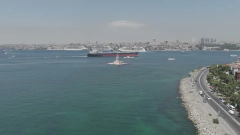 D-Log M. Istanbul, Turkey. Maidens Tower K?z Kulesi with cargo ship and cruise Stock Footage 317074487