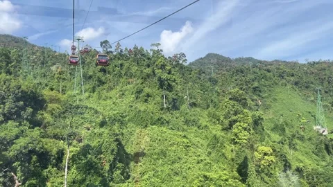 Da Nang Vietnam 10.27.2025 Cable cars in Da Nang Vietnam passing above mountains Stock Footage 320162983