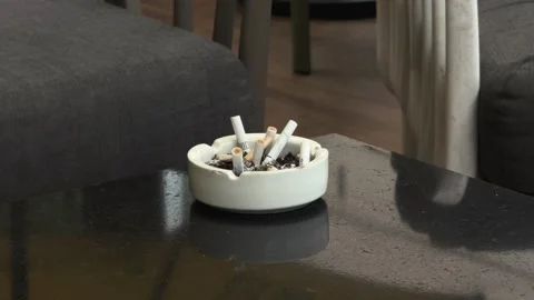 Da Nang, Vietnam - August 3, 2026: Ashtray Full of Cigarette Butts on Cafe Stock Footage 344353076
