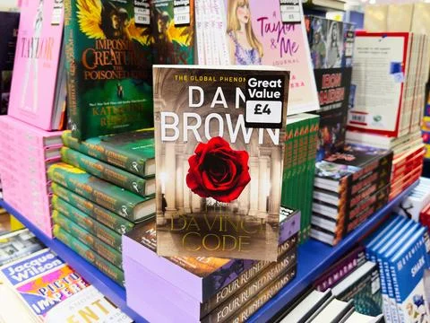 The Da Vinci Code by Dan Brown on a bookstore shelf with a striking red ros.. Foto stock