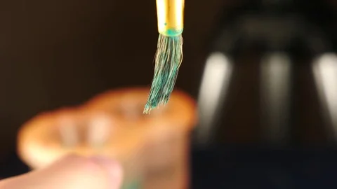 Dabs a brush in a jar with green paint. someone draws paint on a white sheet Stock Footage 82457638