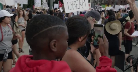 DACA supporter taking a video on his phone during march from Echo Park Lake to Stock Footage 81574649