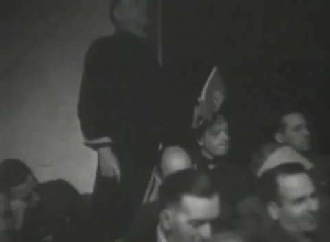 DACHAU, GERMANY - 1947: War crimes court - Man stands among seated court crowd 库存影片 343790751