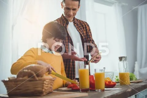 Dad and boy following cooking instruction Stock Photos