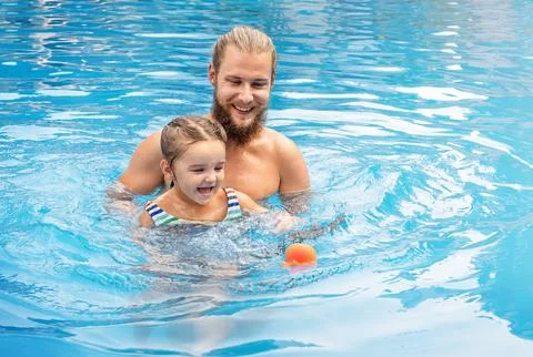 Dad and chikd playing in the pool Stock Photos