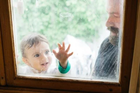 Dad and child looking through the window 스톡 사진