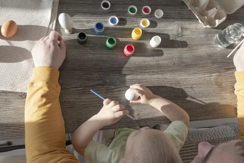 Dad and child paint eggs for Easter. Stock Photos