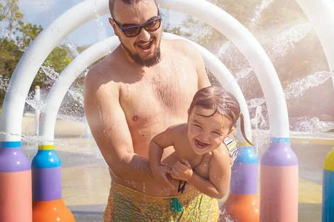 Dad and child run through the splash Stock Photos