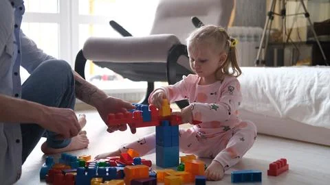 Dad and daughter are building family home. Happy family. Educational games fo Stock Photos