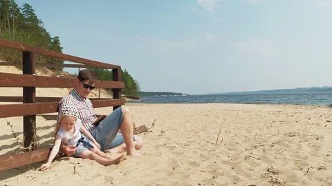 Dad and daughter are using a computer tablet in the open air. River bank 스톡 동영상 108019293