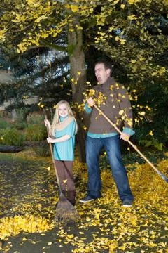 Dad and daughter cannot keep up with the falling leaves Stock Photos