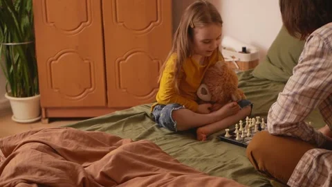 Dad and daughter concentrate while playing chess in bedroom. Stock Footage 269917468