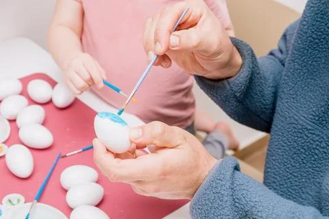 Dad and daughter drawing Easter eggs, man and girl spend time together for .. Stock Photos