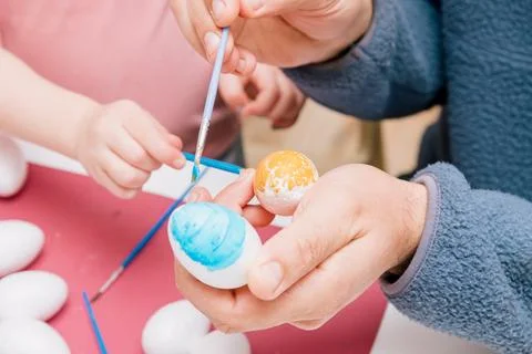 Dad and daughter drawing Easter eggs, man and girl spend time together for .. Stock Photos