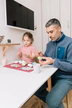 Dad and daughter drawing Easter eggs, man and girl spend time together for .. Stock Photos