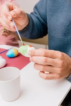 Dad and daughter drawing Easter eggs, man and girl spend time together for .. Stock Photos