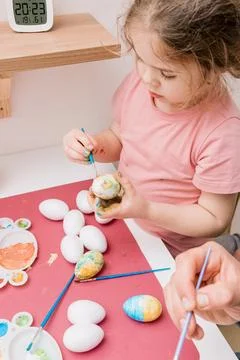 Dad and daughter drawing Easter eggs, man and girl spend time together for .. Stock Photos