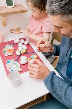 Dad and daughter drawing Easter eggs, man and girl spend time together for .. Stock-Fotos