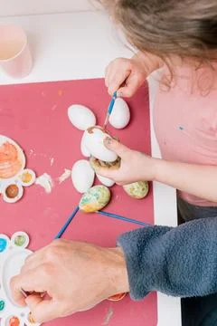 Dad and daughter drawing Easter eggs, man and girl spend time together for .. Stock Photos