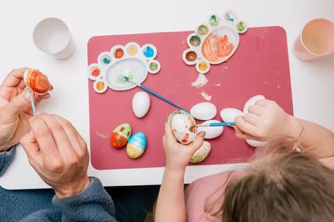 Dad and daughter drawing Easter eggs, man and girl spend time together for .. Stock Photos
