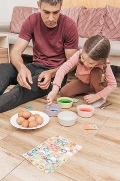 Dad and daughter drawing Easter eggs, man and girl spend time together for .. Stock Photos