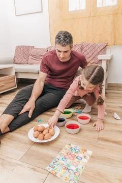 Dad and daughter drawing Easter eggs, man and girl spend time together for .. Stock Photos