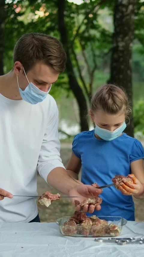 Dad and daughter stringing marinated meat on skewers. A family wearing medi.. Stock Footage 305846871