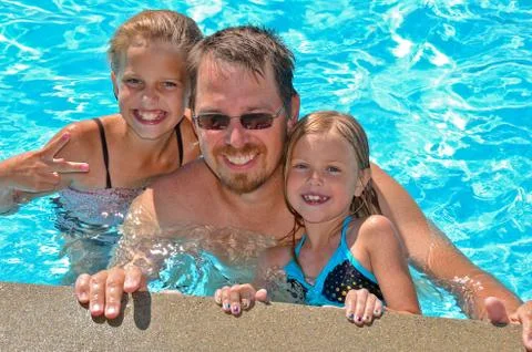 Dad and daughters in pool Stock Photos