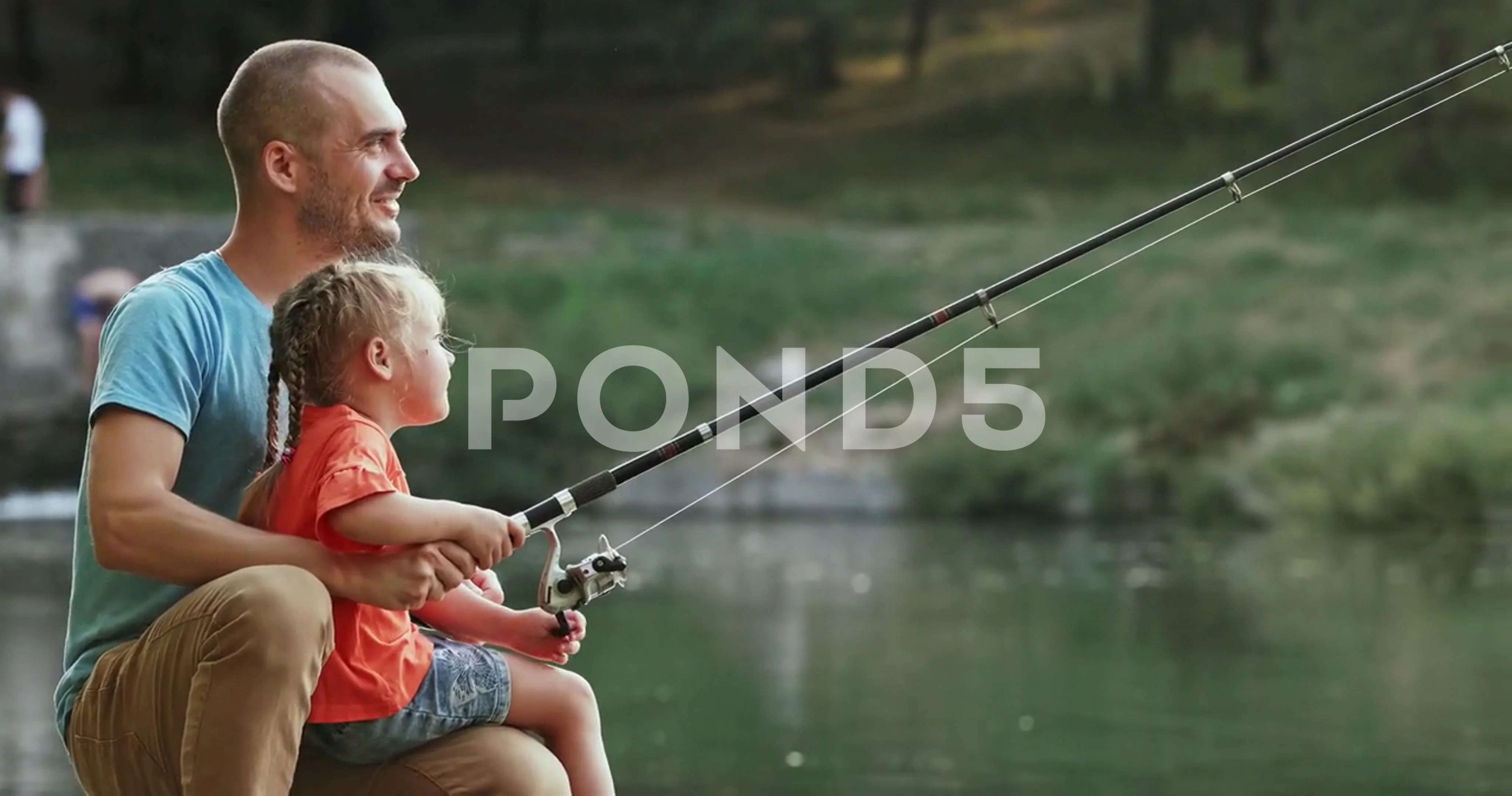 Dad and little daughter sit on river ban, Stock Video