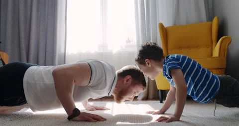 Dad and little son do sports, float at home by the sun window. Stock Footage 151084164