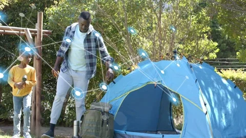 Dad and son approaching blue tent nodes activating as man pointing checking Stock Footage 333949965