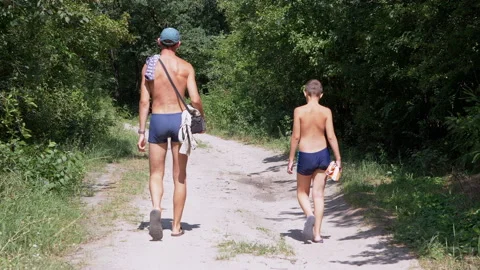 Dad and Son are Walking Along a Sandy Path in a Green Woods. Slow motion Stock-Footage 166677534
