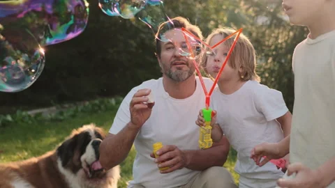 Dad and son blow bubbles on the lawn near the house. Stock Footage 217801217