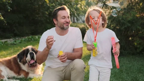 Dad and son blow bubbles on the lawn near the house. Stock Footage 217803297