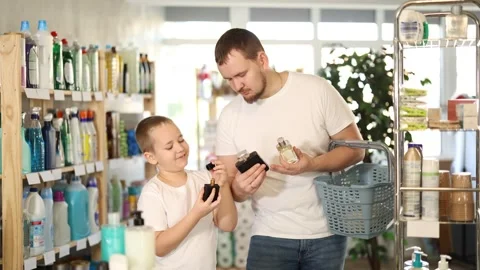 Dad and son client sniffs fragrance of perfume, chooses scent spray with Stock-Footage 318941849