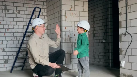 Dad and son at the construction site are happy to get a new apartment Stock Footage 238080768