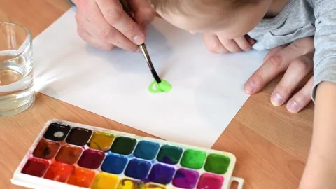 Dad and son drawing a green leaf of clover  with watercolors. Stock Footage 150730705