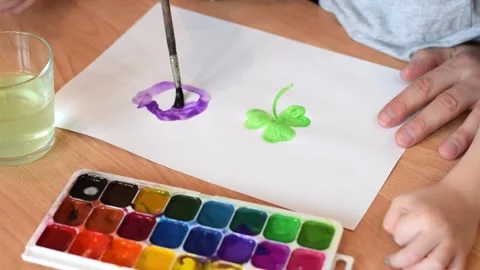 Dad and son drawing a leaf of clover with watercolors. Stock Footage 150730647