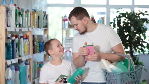 Dad and son filled shopping basket with household purchases, looking for missing Stock Footage 308754273