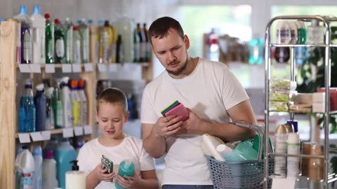 Dad and son filled shopping basket with household purchases, looking for missing Stock Footage 321330872