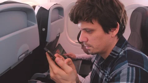 Dad and son in gadgets on Board the plane during the flight. Stock Footage 116590459