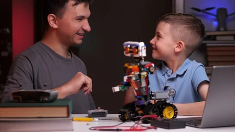 Dad and son give five to each other next to the robot Stock Footage 238678498